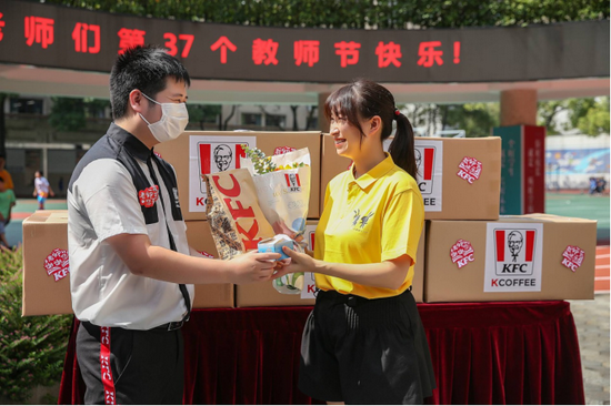 (老师代表从肯德基工作人员手中接过爱心餐点和鲜花)