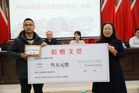 (开福区委统战部常务副部长王凤向内溪学校副校长授发爱心捐款)