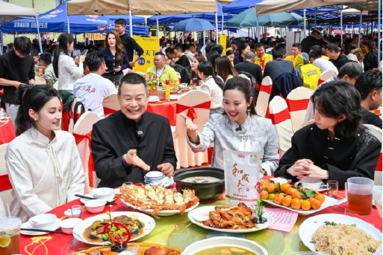 广府文化学者饶原生（左二）在万人宴现场，解读岭南文化