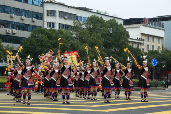 图为非遗巡游现场，翻腾的彩龙与特色民俗方阵点燃街头热情。