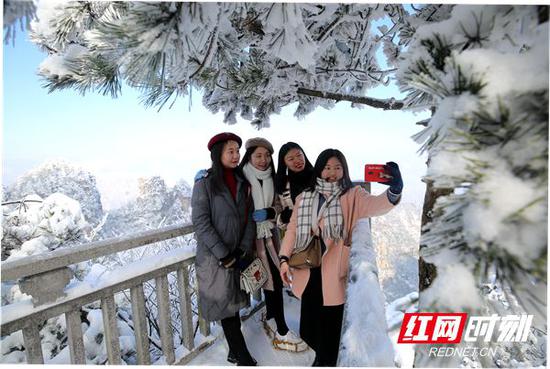 游客在武陵源核心景区雪景中拍照留念。2018年,武陵源区年接待量达3028.89万人次,创历史新高。