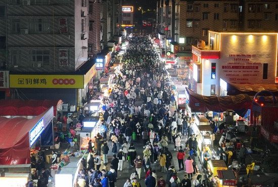 (1月26日晚,长沙市开福区四方坪商贸城夜市烟火气升腾,众多市民、游客在夜市里穿行,品尝美食。)