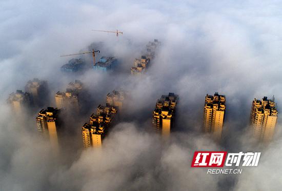 12月17日上午,雁城上空。浓云密布,大雾锁城,建筑物海市蜃楼般若隐若现,蔚为壮观。
