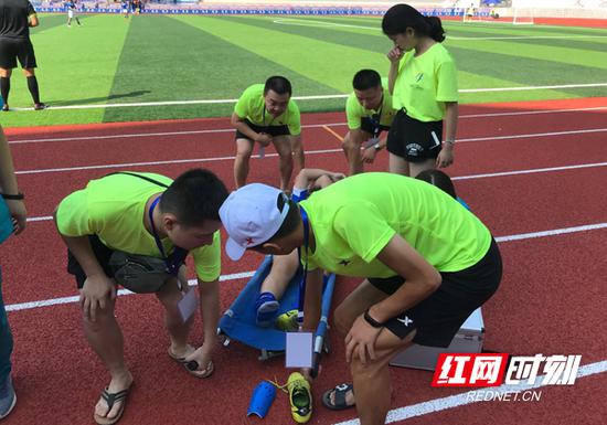益阳女队6号球员吴羊在赛场上拼抢受伤,南岳志愿服务者和医疗救护人员共同接力。