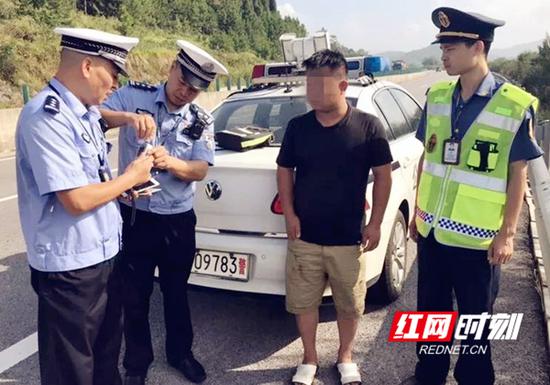 新邵大队民警正在对醉酒男子进行酒精测试。