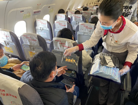湖南航空乘务员向乘客派发防护口罩