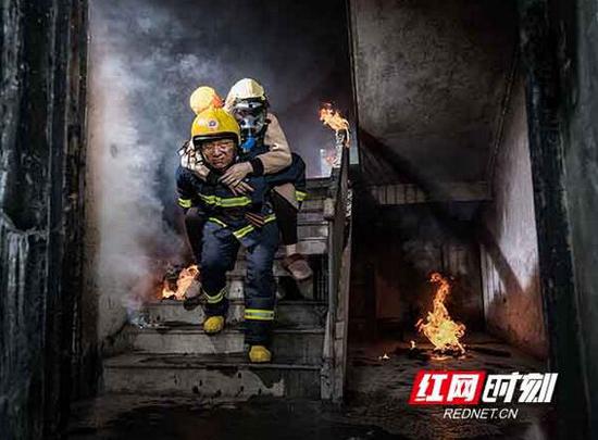 廖仲国将自己的呼吸器取下给受困人员,然后艰难地背起她沿楼梯疏散到一楼安全区。