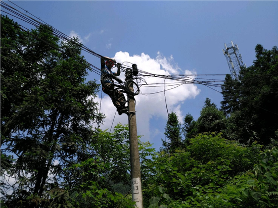 电信施工人员在山顶架设光缆。