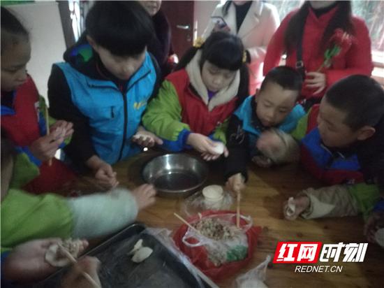 小志愿者与福利院孩子们一起包饺子。