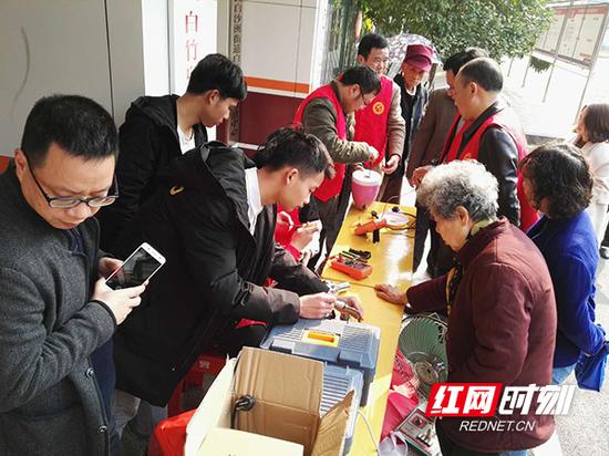 “雷锋家电维修队”志愿者为空巢老人免费维修家电。