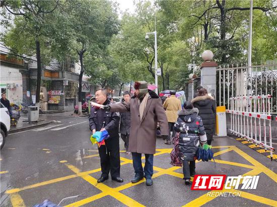 刘魁成老人在疏导交通。