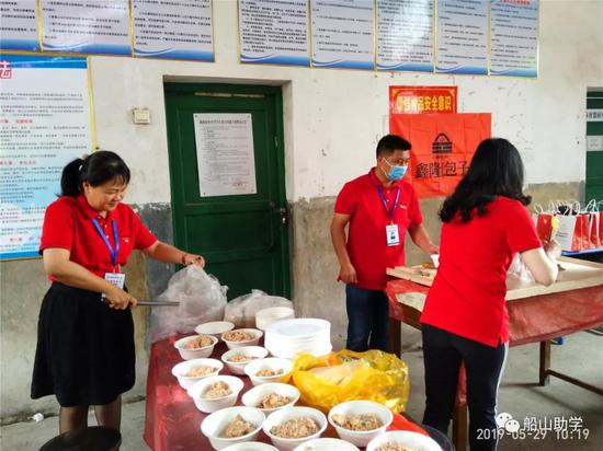 图:志愿者一起给小朋友们分配食材