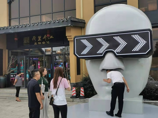  游客打卡巨型“人脸面具像”