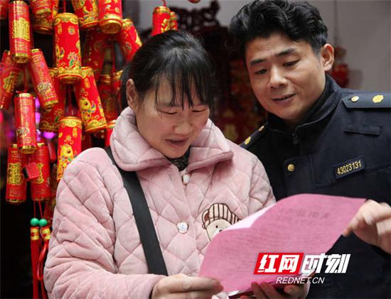 衡阳县城管队员龙章斌向市民发春节“禁炮”宣传单。