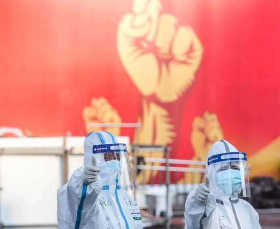 2月12日，两名医护人员在武汉体育中心方舱医院竖起拇指为自己和同伴加油鼓劲。新华社记者 肖艺九 摄