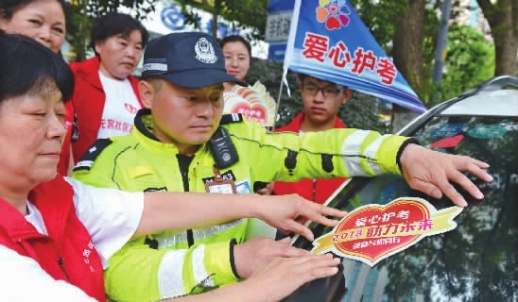 6月5日，民警与志愿者一起为爱心车主张贴“爱心送考绿色直通车”标志。      记者 徐行 摄 