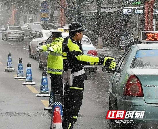 南岳交警在风雪中指挥交通。