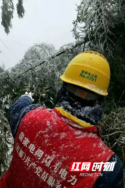 电力工作人员的工作服已被冰雪浸湿。