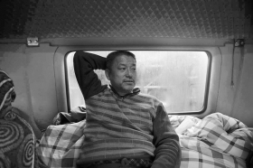 11月17日，星沙，从北京拖包裹过来的货车司机冯海宾斜躺在驾驶室，他已在快递公司门口等了三天，估计当天晚 上或18日凌晨能进场卸货。　图/记者陈正