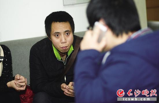 近日，长沙志愿者为失忆者顾远(左)联系派出所，看能否帮他找到家人。长沙晚报记者 李锋 摄