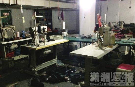 12月28日，长沙芙蓉区环卫公寓地下室，皮鞋厂内摆放着多台机器，皮料乱堆，插线板悬在半空。