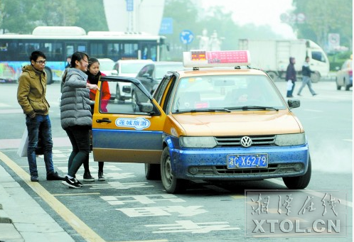 春节三天，出租车将临时加价５元。图为１月１３日，市民在建设路口附近乘坐出租车。（记者 欧阳天 摄）