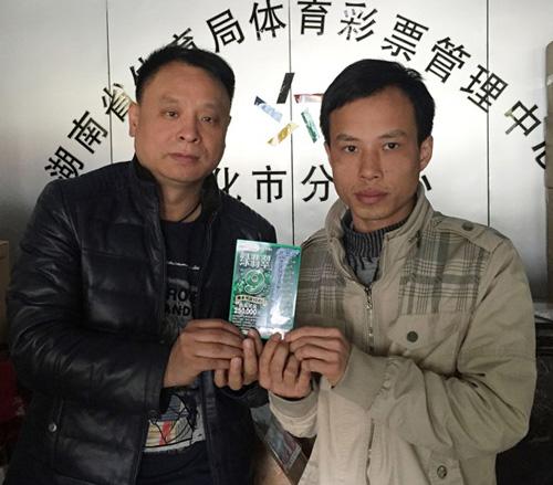 怀化市体彩分中心副主任林勇华(左)与顶呱刮25万大奖得主张先生(右)合影