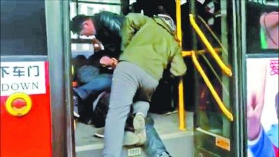 反扒民警将小偷扑倒在公汽下车门处。