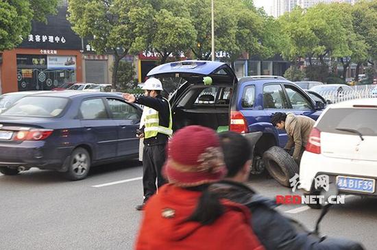 图为交警张坚在车流中指挥交通，维护救援现场安全秩序。