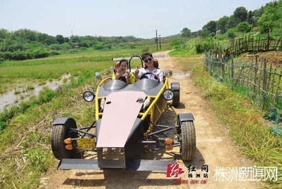 文超开着仿版“原子跑车”载着他的老婆孩子兜风