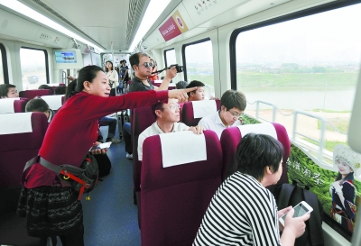 5月6日上午，长沙磁浮列车上，乘客透过车窗看沿线的风景。 记者 田超 徐行 摄