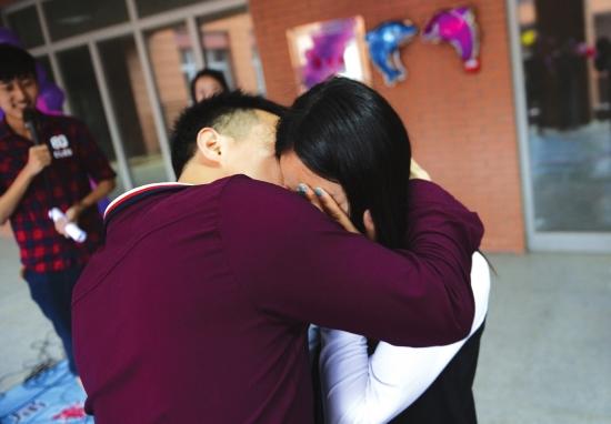 5月7日，长沙西湖公园，众多高校的学生组织了一场亲吻陌生人的活动，男生主动拥抱并亲吻女生脸颊时，女生用手蒙住脸。 图/记者辜鹏博实习生王悦婷