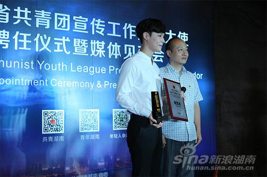 共青团湖南省委宣传部部长彭力（右）为张艺兴颁发聘书与奖杯。（摄影：易举）