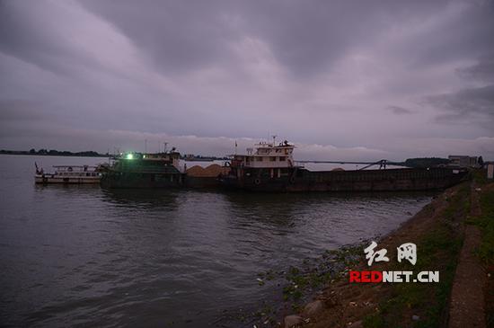 一艘采沙船向湘江河段内堤渗水面灌注水泥砂石。