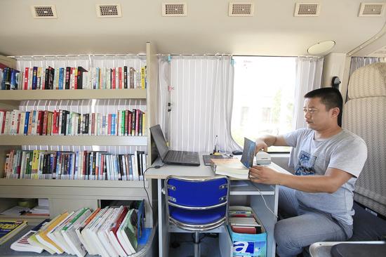 天心区图书馆移动图书馆馆员甘文元正在为读者办理借书手续。