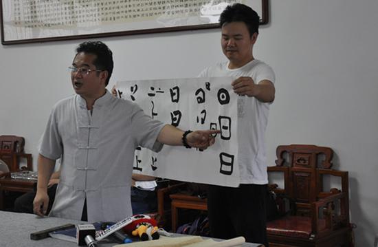 湖南书法名家范晓亮（左）讲解汉字的演变。