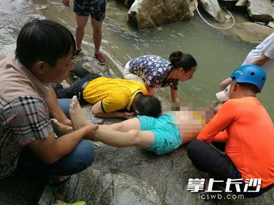 女子失足坠入深潭,几名热心人士闻讯潜入水底将其救出并展开现场急救,遗憾的是该女子最终因溺水时间过长而不治。 网友供图