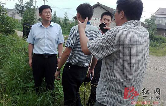 汉寿县委书记杨昶(左一)察看受灾现场。