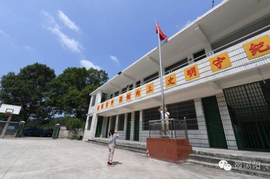 即使只有一个老师和一个学生的升旗仪式，张安连老师带着学生张秋香举行得同样庄严肃穆。