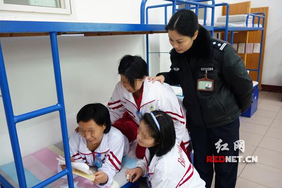湖南省白马垅强戒所的宿舍里，三大队队长曾丽英在戒毒人员旁边看她们的书信。