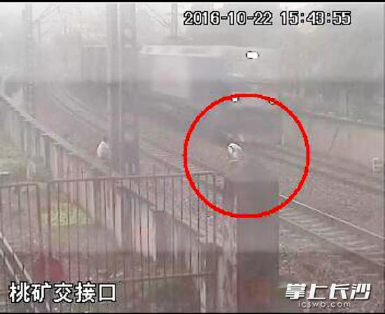 22日15时43分55秒，火车即将驶到跟前，穿白色上衣的男孩才迅速跳离轨道。 均为视频监控截图