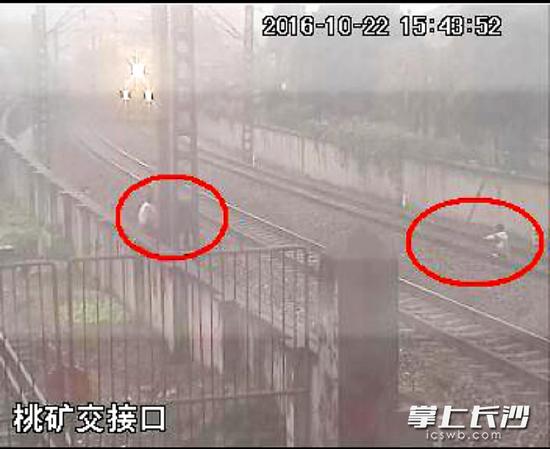 22日15时43分52秒，火车急驶而来，一个穿白色上衣的男孩仍蹲在轨道上，另外几个孩子在铁道边上看着。