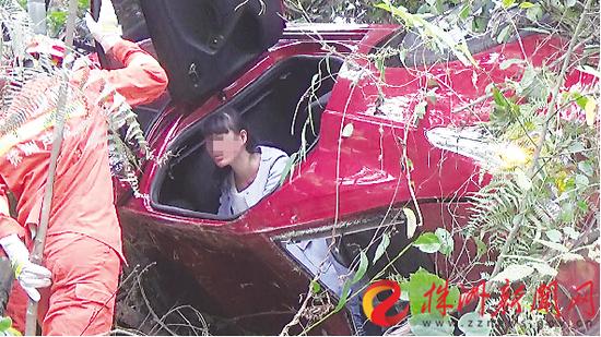 轿车滚下土坡，女司机被困，消防员正在救援(通讯员 刘钊 摄)
