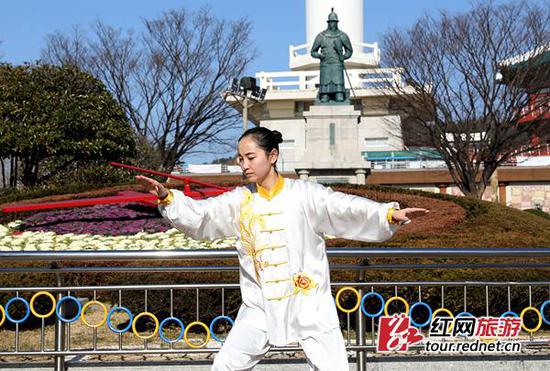 湖南省十佳导游贺珍芳在韩国釜山龙头山公园展示气功。