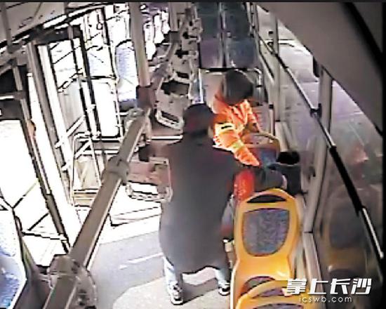 公交车司机肖龙和环卫工粟巧云将老人扶到座位上。