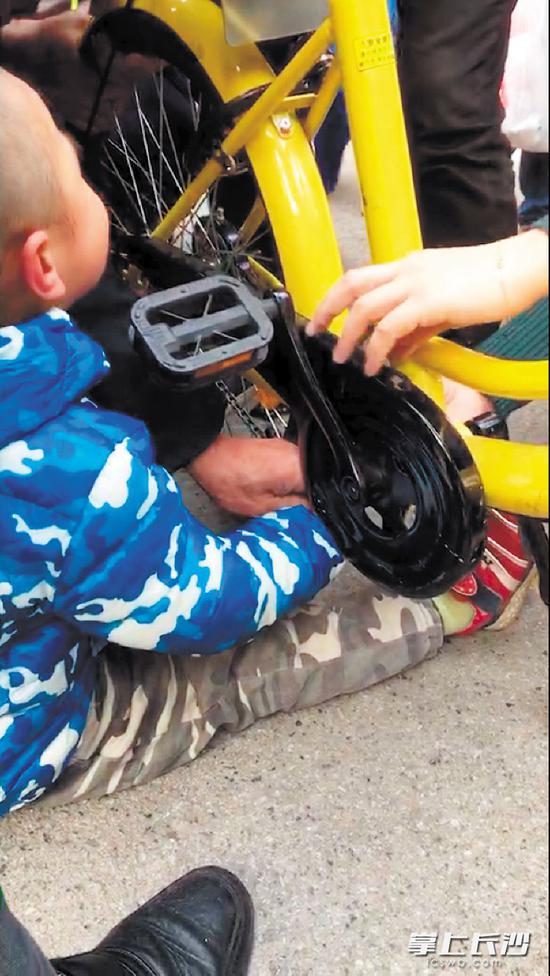 昨日,雷锋大道附近一小区门口,小孩在玩共享单车时,手指被卡。目击者 刘先生供图
