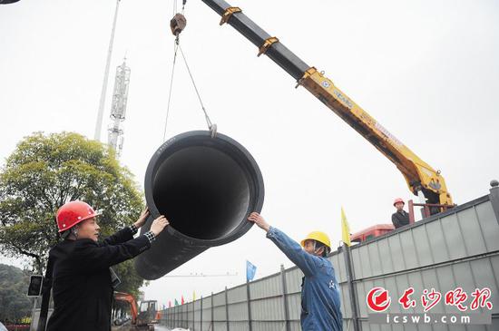 昨日上午，市民代表来到江南水务建安公司施工现场参观，新型的球墨铸铁管正在吊装。
