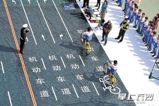 昨日上午,“安全骑行”主题宣传进校园活动在湘雅路三角塘小学举行,通过在学校操场模拟交通十字路口,让小学生学习体验安全骑行方式。 长沙晚报记者 王志伟 摄