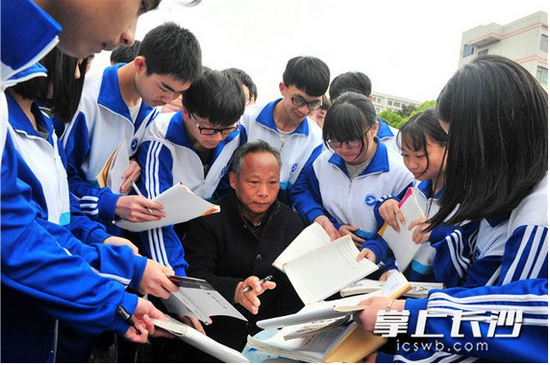 活动结束后,同学们纷纷向校友刘金甫索要签名。长沙晚报记者 贺文兵 摄