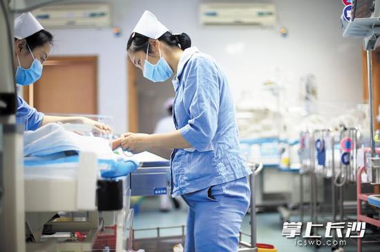 长沙市中心医院新生儿科身怀六甲的护士童慧玲，正专心给患儿打针。长沙晚报通讯员 吴小兵 摄